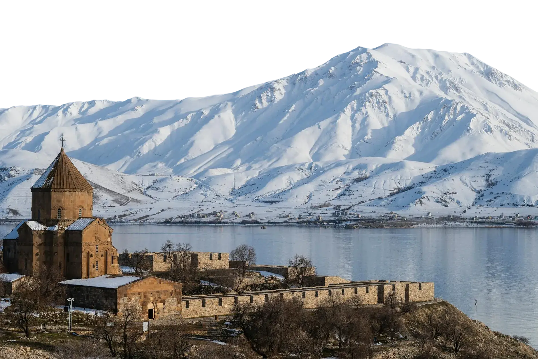 The Church of the Holy Cross on Akdamar Island in Lake Van, with snow covered mountains behind it