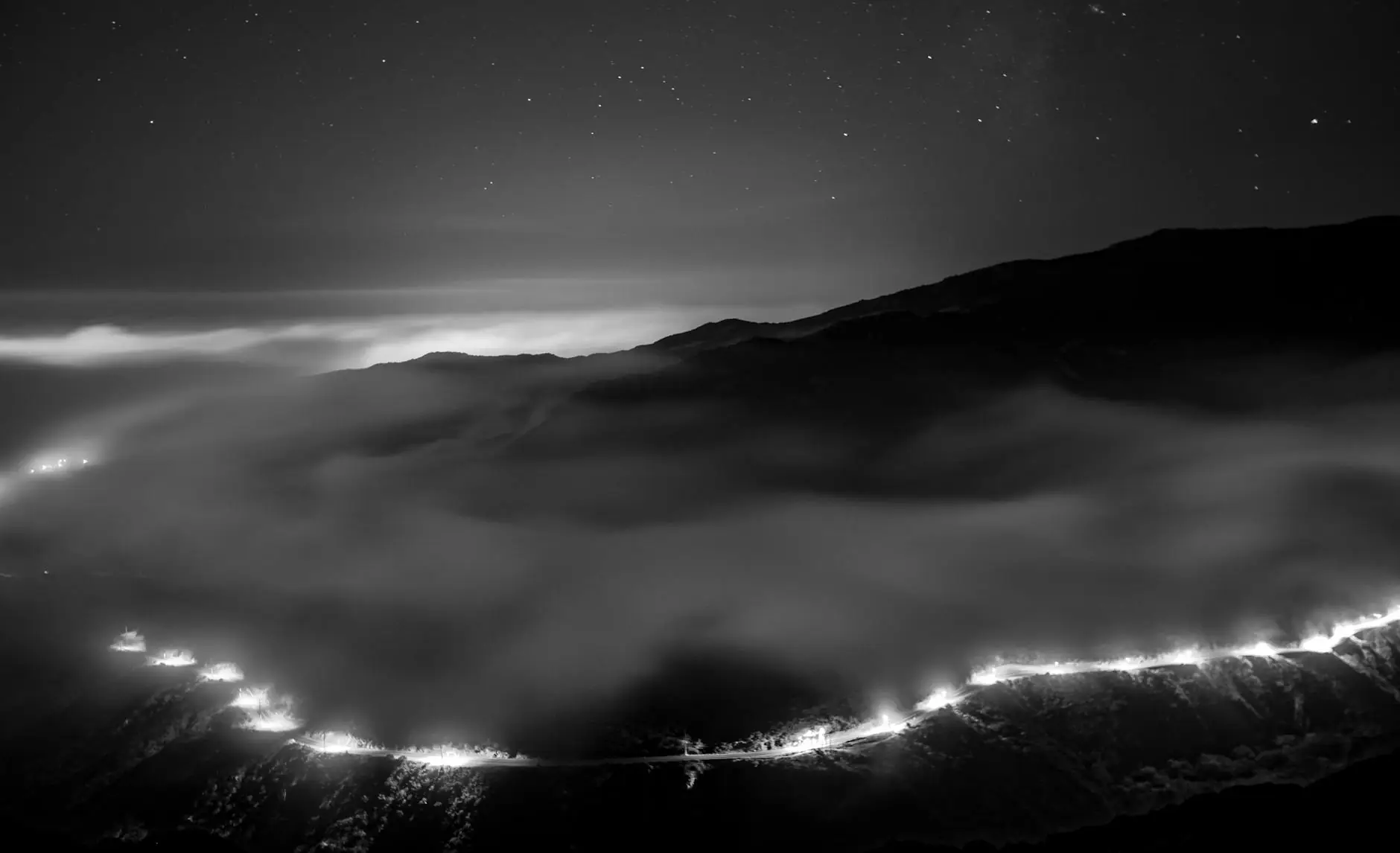A mountainside at night with a line of lights along the ridge