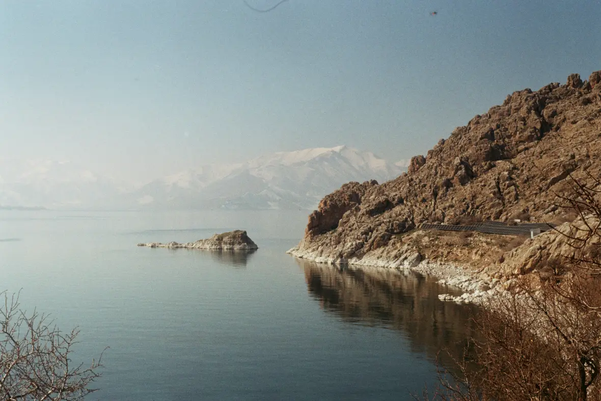 The rocky shore of Lake Van, with snow-capped mountains behind