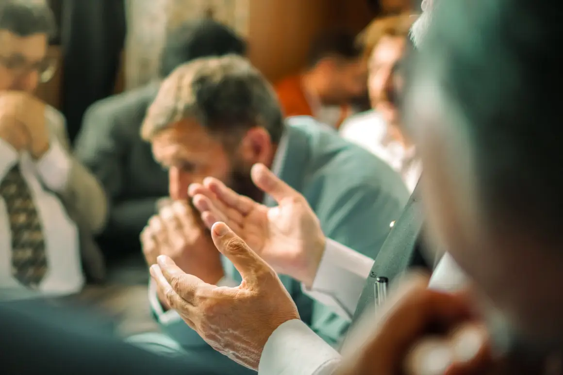 People at a prayer meeting, hands open in prayer