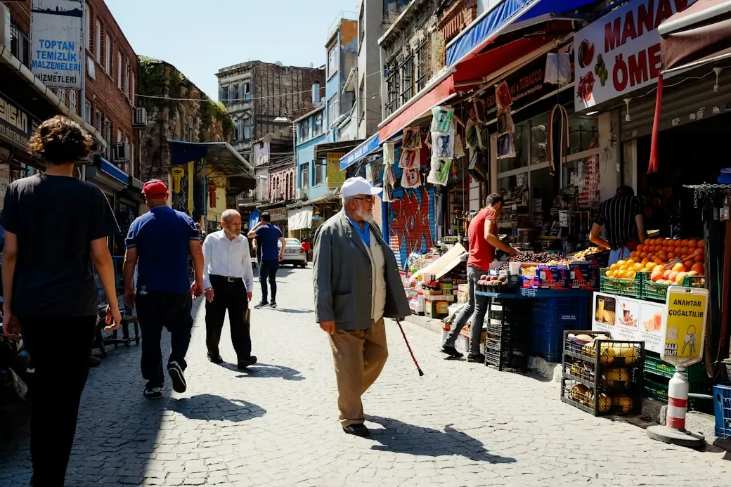 A busy market street lined with fruit stalls and shops