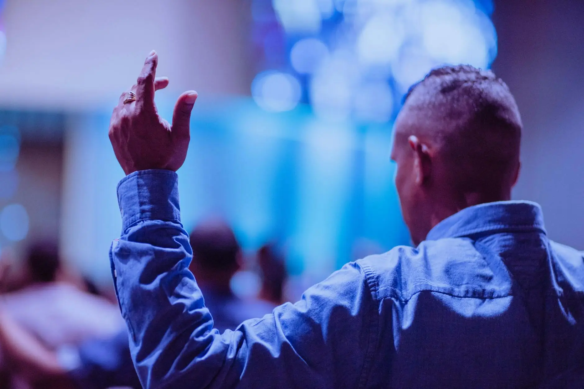A man raising his hand in worship during a church service